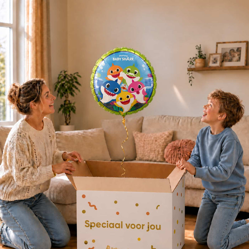 Moeder en kind bekijken een Baby Shark-heliumballon van 43 cm boven een geopende cadeaudoos.