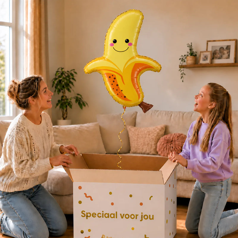 Banaan Helium XL Ballon – uitpakmoment met moeder en meisje in een warme woonkamer – Ballonnenshop.nl