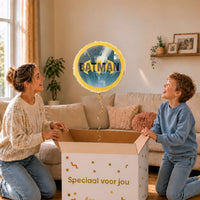 Moeder en jongen bekijken de ballon Batman Helium Ballon in zacht warm licht boven de geopende cadeaudoos ‘Speciaal voor jou’.