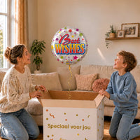 Moeder en jongen bekijken een Best Wishes-ballon van 46 cm met kleurrijke letters en sterren boven een geopende cadeaudoos.
