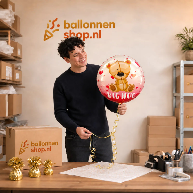 Jesse houdt de Big Hug Helium Ballon vast in de warme werkplaats van Ballonnenshop.nl.