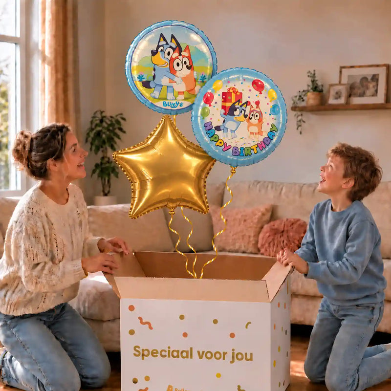 Bluey Happy Birthday Trosje Blauw: moeder en zoon pakken het heliumgevulde ballonnentrosje uit een Speciaal voor jou-doos, met natuurlijk gekrulde gouden linten.
