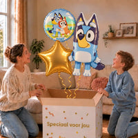 Bluey Trosje: moeder en zoon pakken het heliumgevulde ballonnentrosje uit een Speciaal voor jou-doos, met natuurlijk gekrulde gouden linten.
