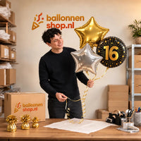 Jesse houdt 16 Jaar Trosje Zilver/Zwart/Goud vast in de warme werkplaats van Ballonnenshop.nl.