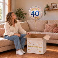 Vrouw viert 40 jaar met Cheers To 40 Years Helium Ballon uit een cadeaudoos van Ballonnenshop.nl