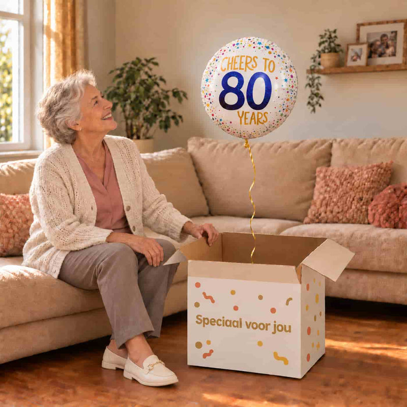Vrouw viert haar 80e verjaardag met een Cheers To 80 Years heliumballon uit een cadeaudoos van Ballonnenshop.nl