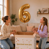 Cijfer 6 Helium Ballon Goud zweeft boven een geopende cadeaudoos bij een moeder en meisje in een warme woonkamer.