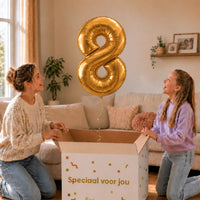Cijfer 8 Helium Ballon Goud zweeft boven een geopende cadeaudoos bij een moeder en meisje in een warme woonkamer.