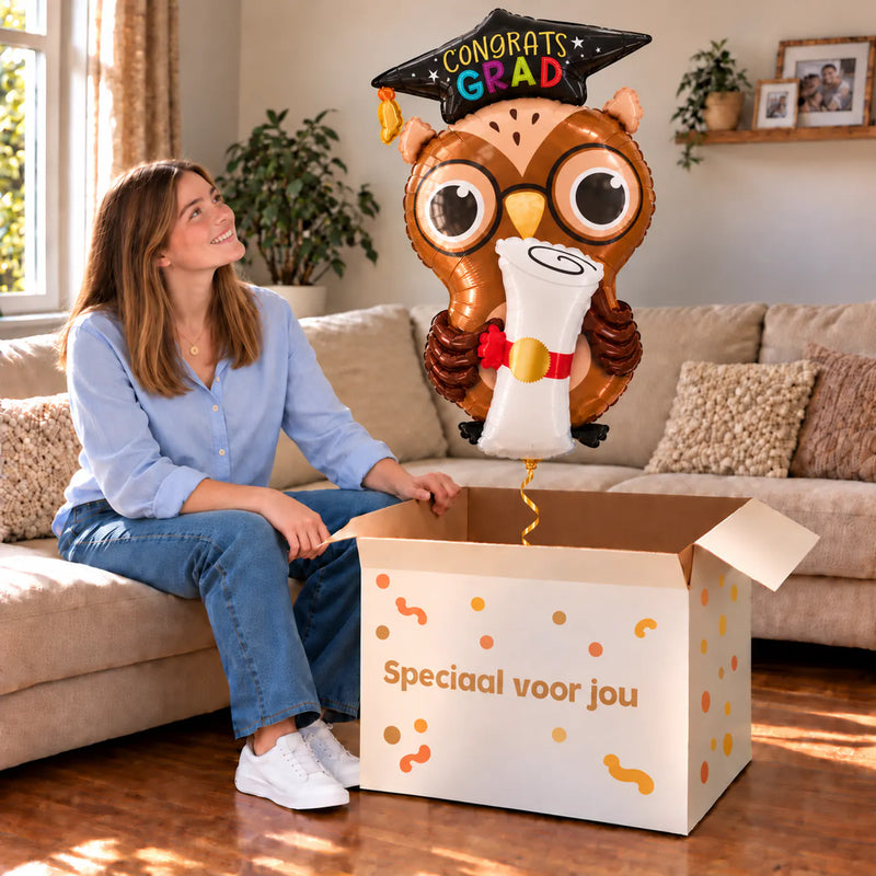 Congrats Grad Uil Ballon gevuld met helium, feestelijk uit een cadeaudoos in een warme woonkamer