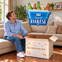 Een man kijkt blij naar Dad You're The Coolest XL Ballon boven een grote Speciaal voor jou-doos in een warme woonkamer.