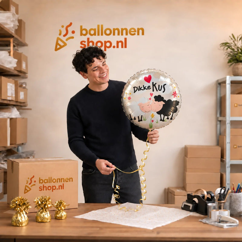 Jesse houdt de Dikke Kus Helium Ballon vast in de warme werkplaats van Ballonnenshop.nl.