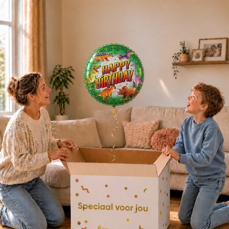 Moeder en jongen bekijken een groene Happy Birthday-ballon van 46 cm met dinosaurussen boven een geopende cadeaudoos.