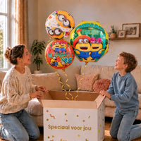 Embrace Your Friends Minion Trosje: moeder en zoon pakken het heliumgevulde ballonnentrosje uit een Speciaal voor jou-doos, met natuurlijk gekrulde gouden linten.