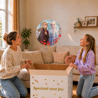 Moeder en meisje bekijken de ballon Frozen Elsa en Anna Helium Ballon in zacht warm licht boven de geopende cadeaudoos ‘Speciaal voor jou’.