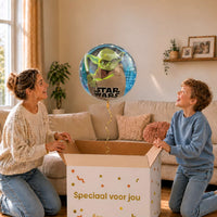 Moeder en jongen bekijken de ballon Galaxy Yoda Helium Ballon in zacht warm licht boven de geopende cadeaudoos ‘Speciaal voor jou’.