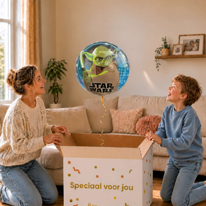 Moeder en jongen bekijken de ballon Galaxy Yoda Helium Ballon in zacht warm licht boven de geopende cadeaudoos ‘Speciaal voor jou’.