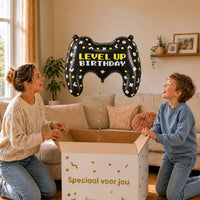 Gamecontroller Level Up XL Ballon – uitpakmoment met moeder en jongetje in een warme woonkamer – Ballonnenshop.nl