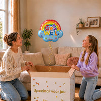 Get Well heliumballon van 45 cm in wolkvorm met regenboog zweeft boven een cadeaudoos bij moeder en meisje.