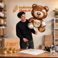 Jesse houdt de Get Well Soon Beer XL Ballon vast in de warme inpakruimte van Ballonnenshop.nl.