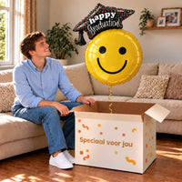 Graduation Smiley XL Ballon gevuld met helium, feestelijk uit een cadeaudoos in een warme woonkamer