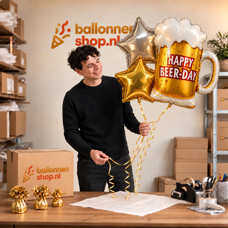 Jesse houdt het Happy Beer Day XL Trosje vast in de warme werkplaats van Ballonnenshop.nl