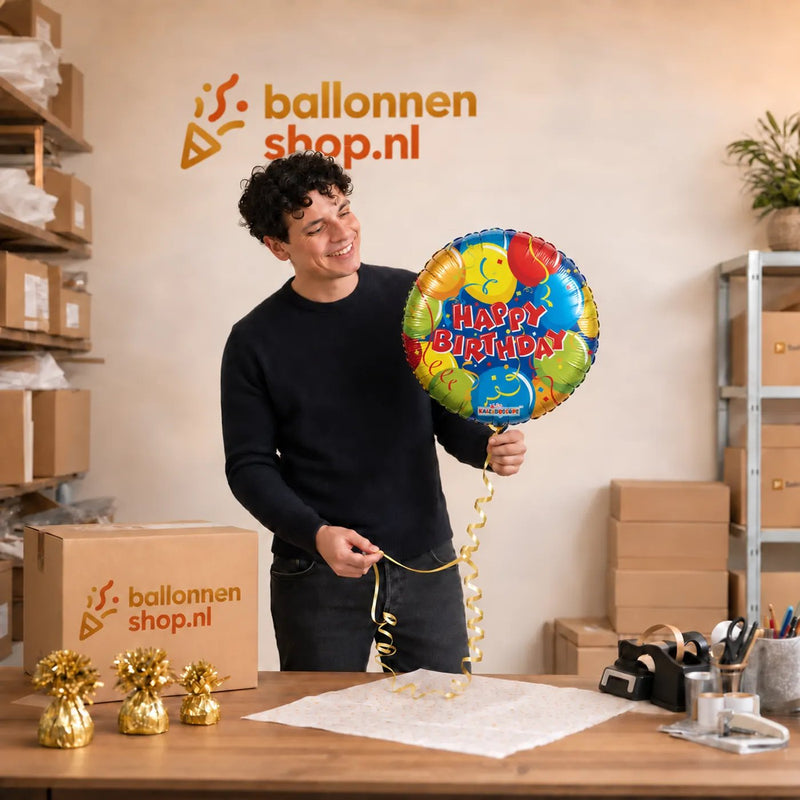 Jesse houdt de Happy Birthday Helium Ballon vast in de warme werkplaats van Ballonnenshop.nl.
