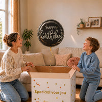 Happy Birthday Crème Noir heliumballon van 46 cm zweeft boven een cadeaudoos bij een moeder en jongen.