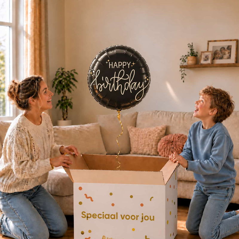 Happy Birthday Crème Noir heliumballon van 46 cm zweeft boven een cadeaudoos bij een moeder en jongen.