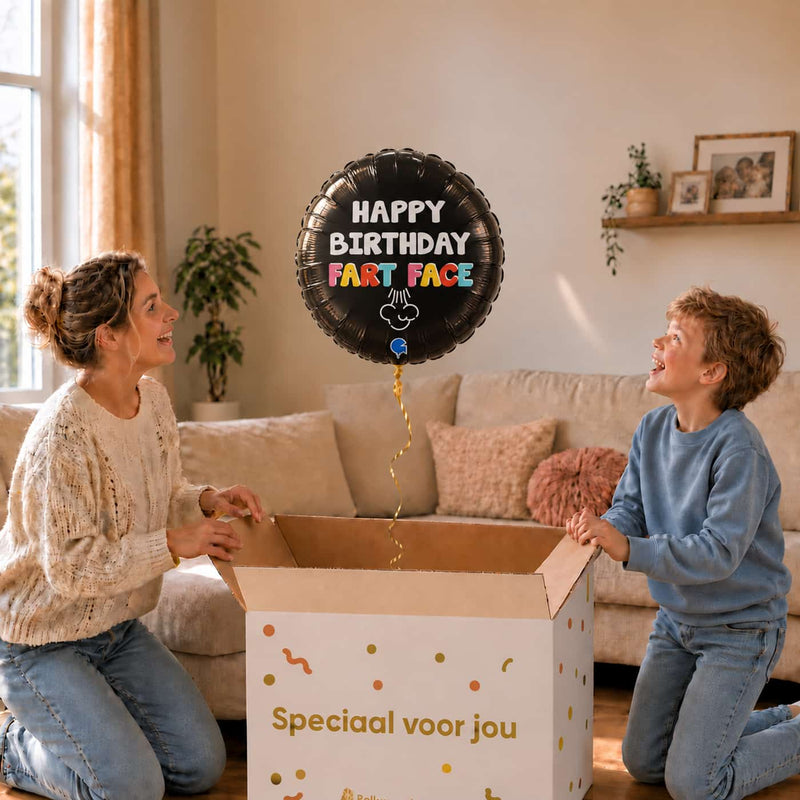 Happy Birthday Fart Face heliumballon van 45 cm zweeft uit een cadeaudoos bij moeder en jongen.