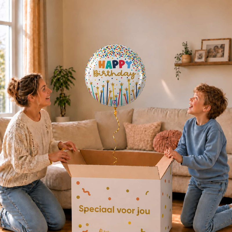 Happy Birthday Kaarsen heliumballon van 45 cm zweeft boven een cadeaudoos bij moeder en jongen.
