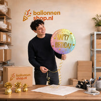 Jesse houdt de Happy Birthday Ombre & Sterren vast in de warme werkplaats van Ballonnenshop.nl.