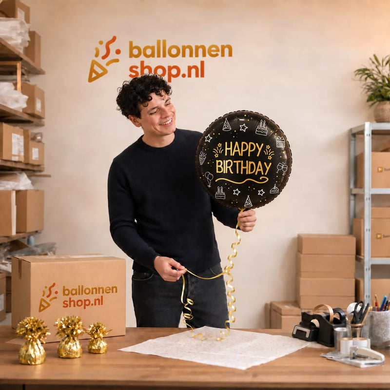 Jesse houdt de Happy Birthday Shining Glam vast in de warme werkplaats van Ballonnenshop.nl.