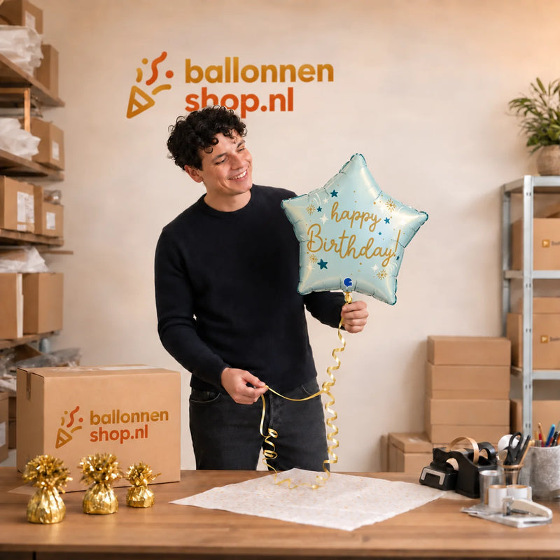 Jesse houdt de Happy Birthday Ster Licht Blauw vast in de warme werkplaats van Ballonnenshop.nl.