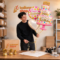 Jesse houdt het Happy Birthday Taart XL Trosje Roze vast in de warme werkplaats van Ballonnenshop.nl
