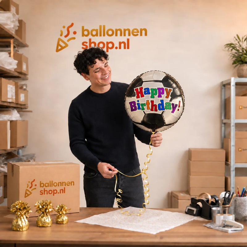 Jesse houdt de Happy Birthday Voetbal Ballon vast in de warme werkplaats van Ballonnenshop.nl.