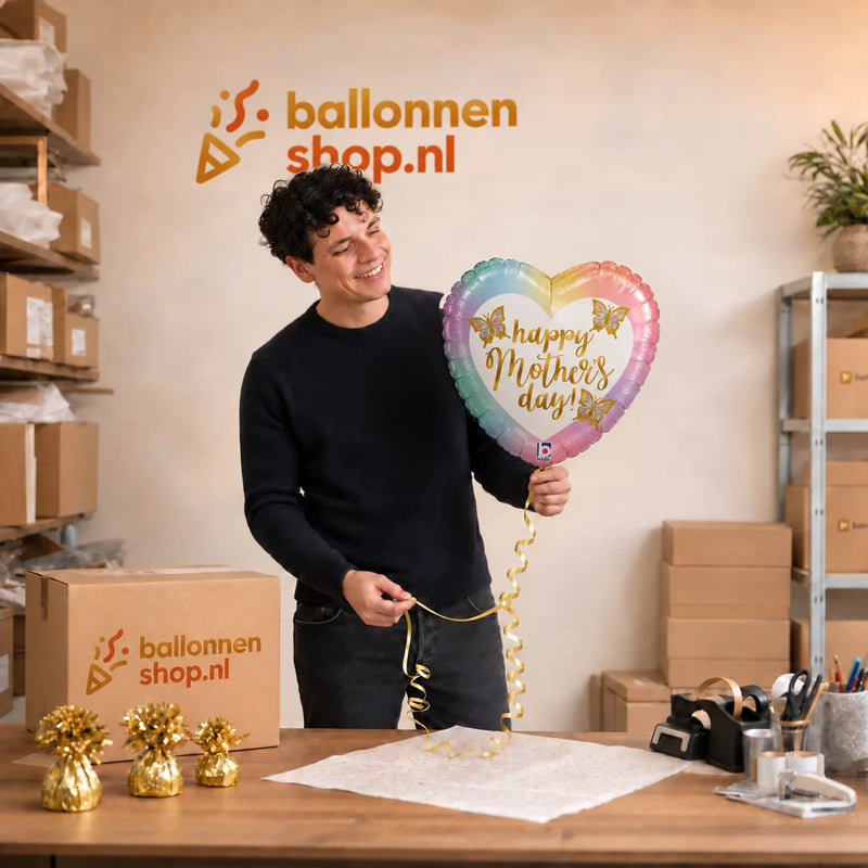 Jesse houdt de Happy Mother's Day Vlinders vast in de warme werkplaats van Ballonnenshop.nl.