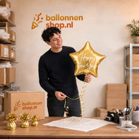 Jesse houdt de Happy New Year Ster Ballon Goud vast in de warme werkplaats van Ballonnenshop.nl.