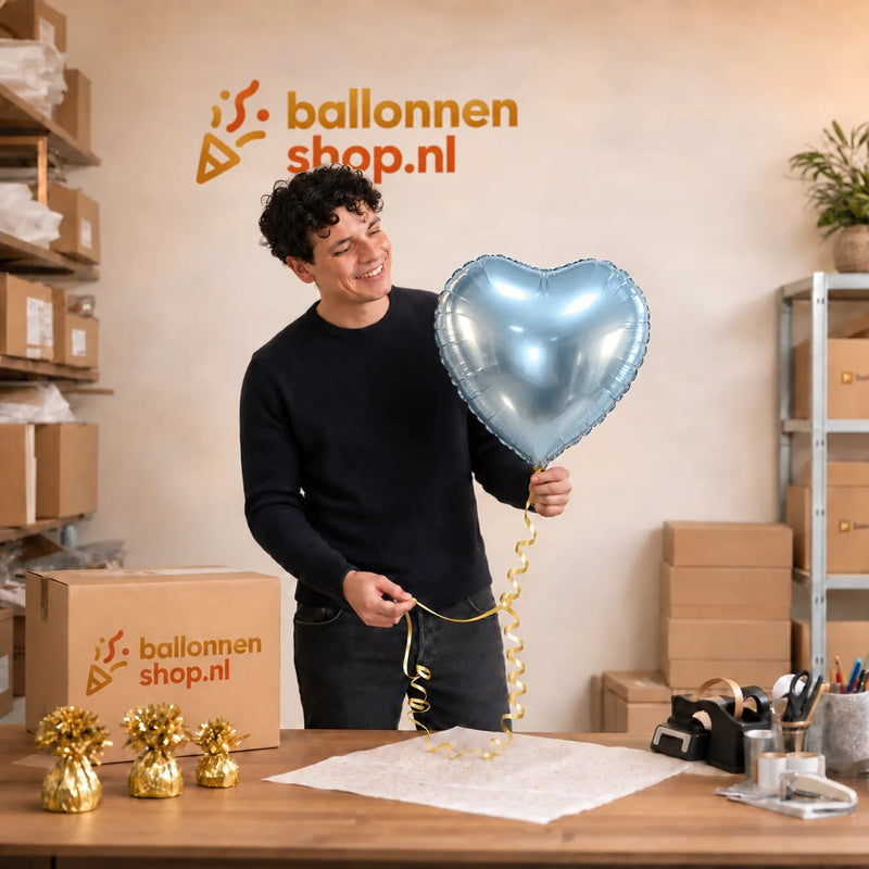 Jesse houdt de Hart Ballon Blauw vast in de warme werkplaats van Ballonnenshop.nl.