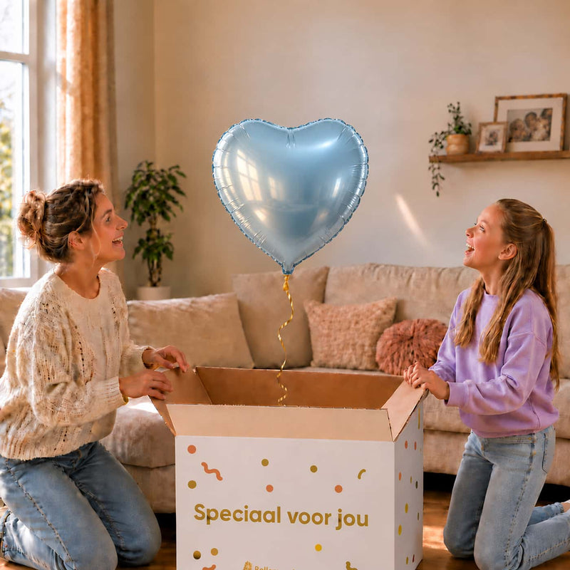 Lichtblauwe hartjesballon van 46 cm zweeft uit een cadeaudoos bij een moeder en meisje.