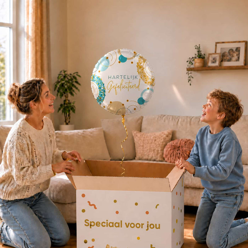 Moeder en jongen pakken een witte Hartelijk Gefeliciteerd heliumballon van 43 cm met turquoise en gouden confetti uit.