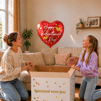 Moeder en meisje pakken een rode hartvormige Happy Valentine's Day heliumballon met gouden en witte hartjes uit.