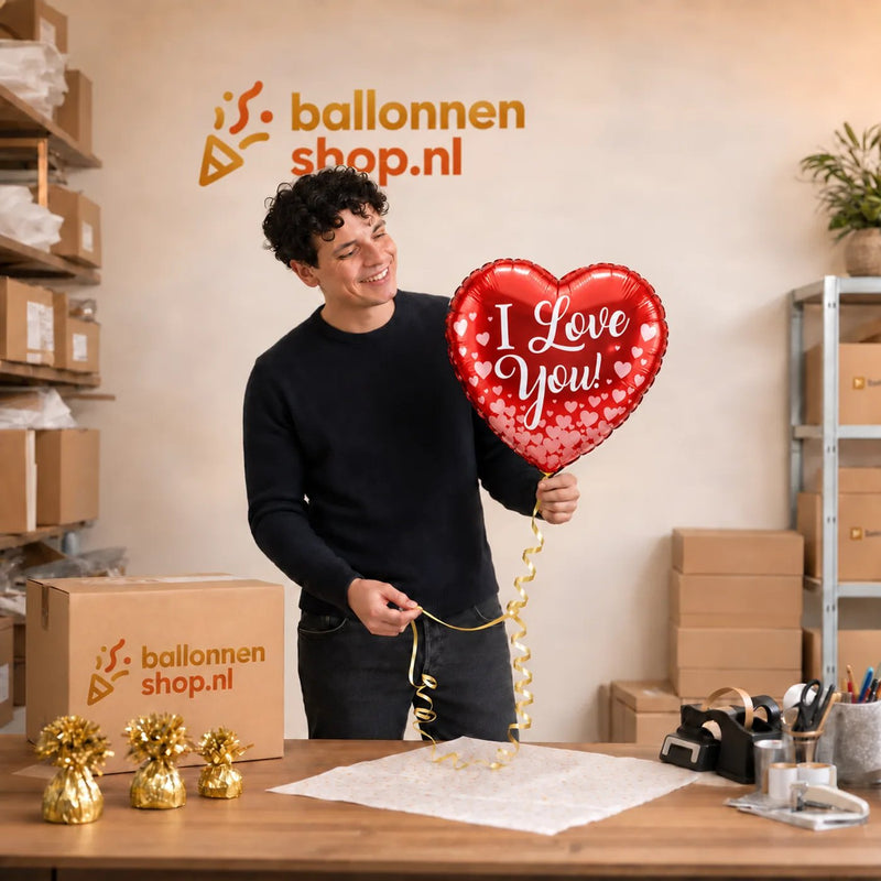 Jesse houdt de Hartjes Ballon I Love You – 43 cm vast in de warme werkplaats van Ballonnenshop.nl.