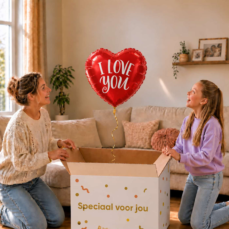 Moeder en meisje bekijken een rode hartballon met witte I Love You opdruk boven de geopende cadeaudoos.