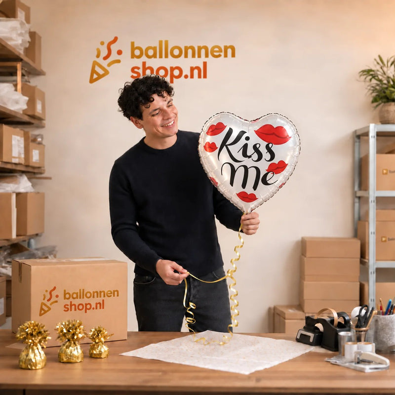 Jesse houdt de Hartjes Ballon Kiss Me vast in de warme werkplaats van Ballonnenshop.nl.