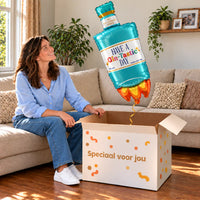 Een vrouw kijkt blij naar Have A Gin – Tastic Day XL Ballon boven een grote Speciaal voor jou-doos in een warme woonkamer.