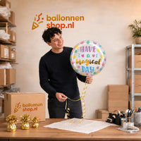 Jesse houdt de Have a Magical Day Helium Ballon vast in de warme werkplaats van Ballonnenshop.nl.