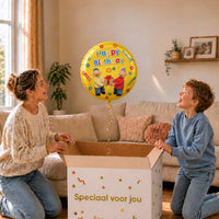 Moeder en jongen pakken een gele Buurman en Buurman Happy Birthday heliumballon met een cadeautje en gereedschap uit.