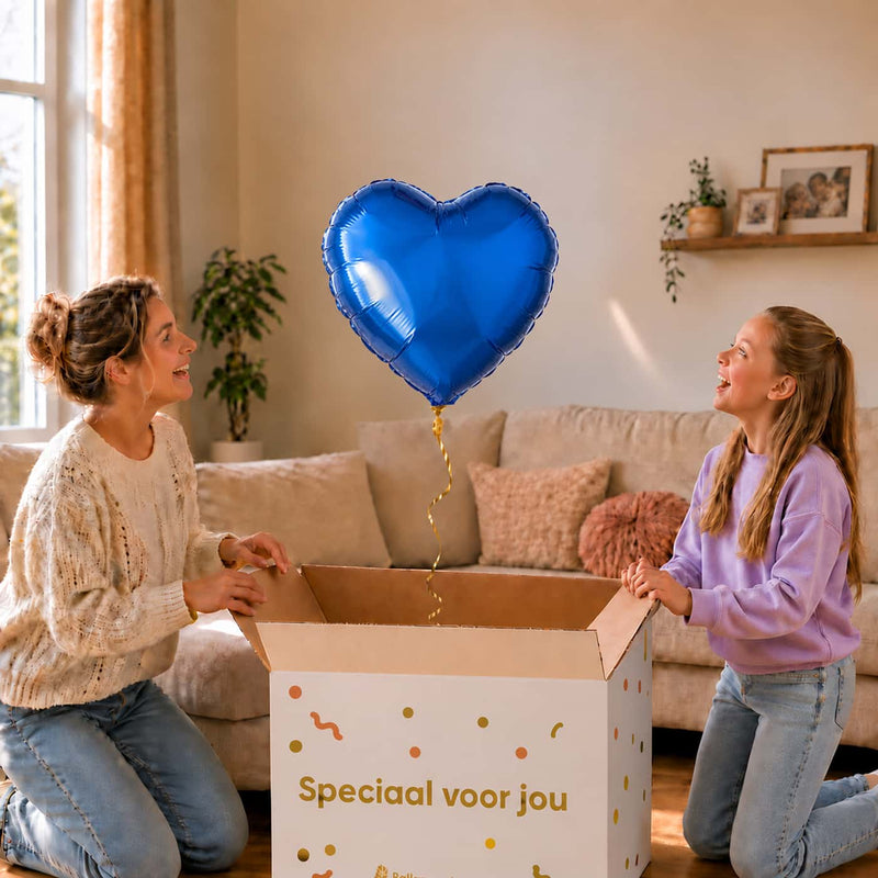 Moeder en meisje bekijken een effen blauwe hartvormige heliumballon van 45 cm boven de open cadeaudoos.