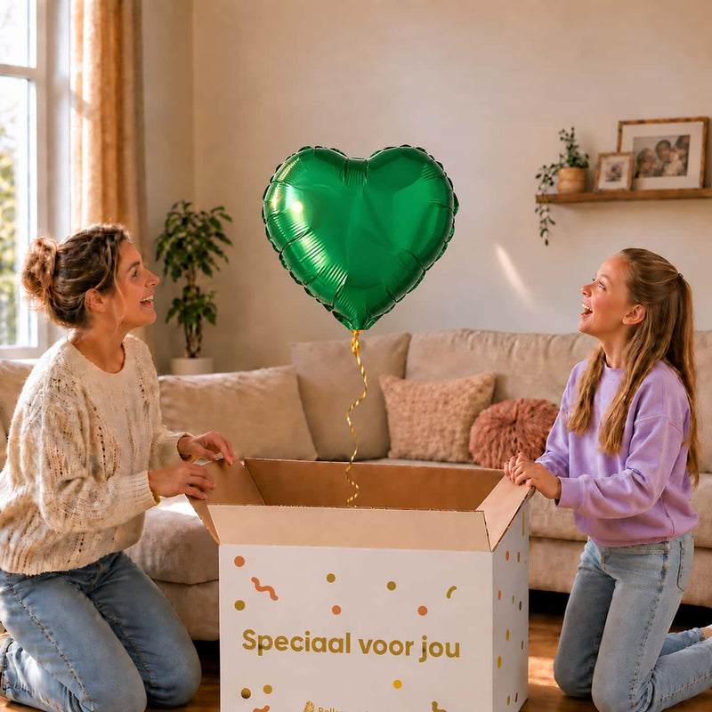 Moeder en meisje bekijken een effen groene hartvormige heliumballon boven de geopende cadeaudoos.