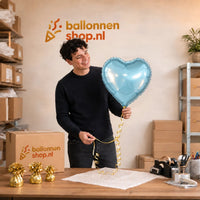 Jesse houdt de Helium Ballon Hart Licht Blauw vast in de warme werkplaats van Ballonnenshop.nl.